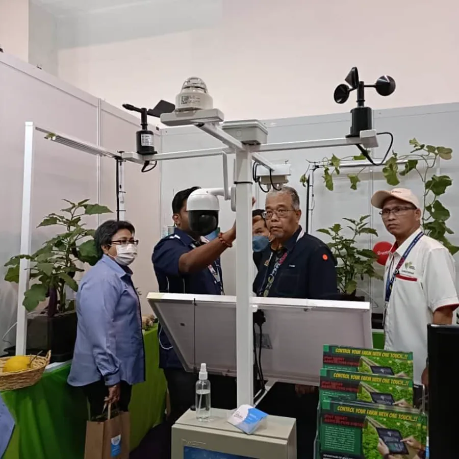Visitors around the JPIoT weather station and sensors on the MAHA 2022 stand