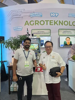 Two men giving a thumbs up in front of the JP Global Engineering stand