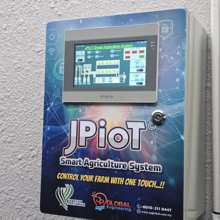 A JPiOT controller mounted on a wall, its touchscreen showing a diagram of tanks and pumps