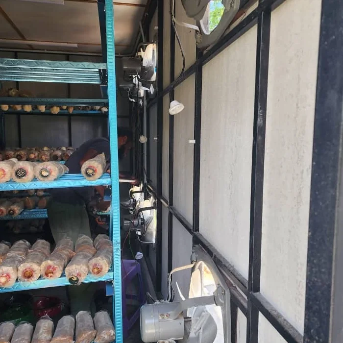 Equipment mounted in a row along the wall facing the racks, with someone working between them